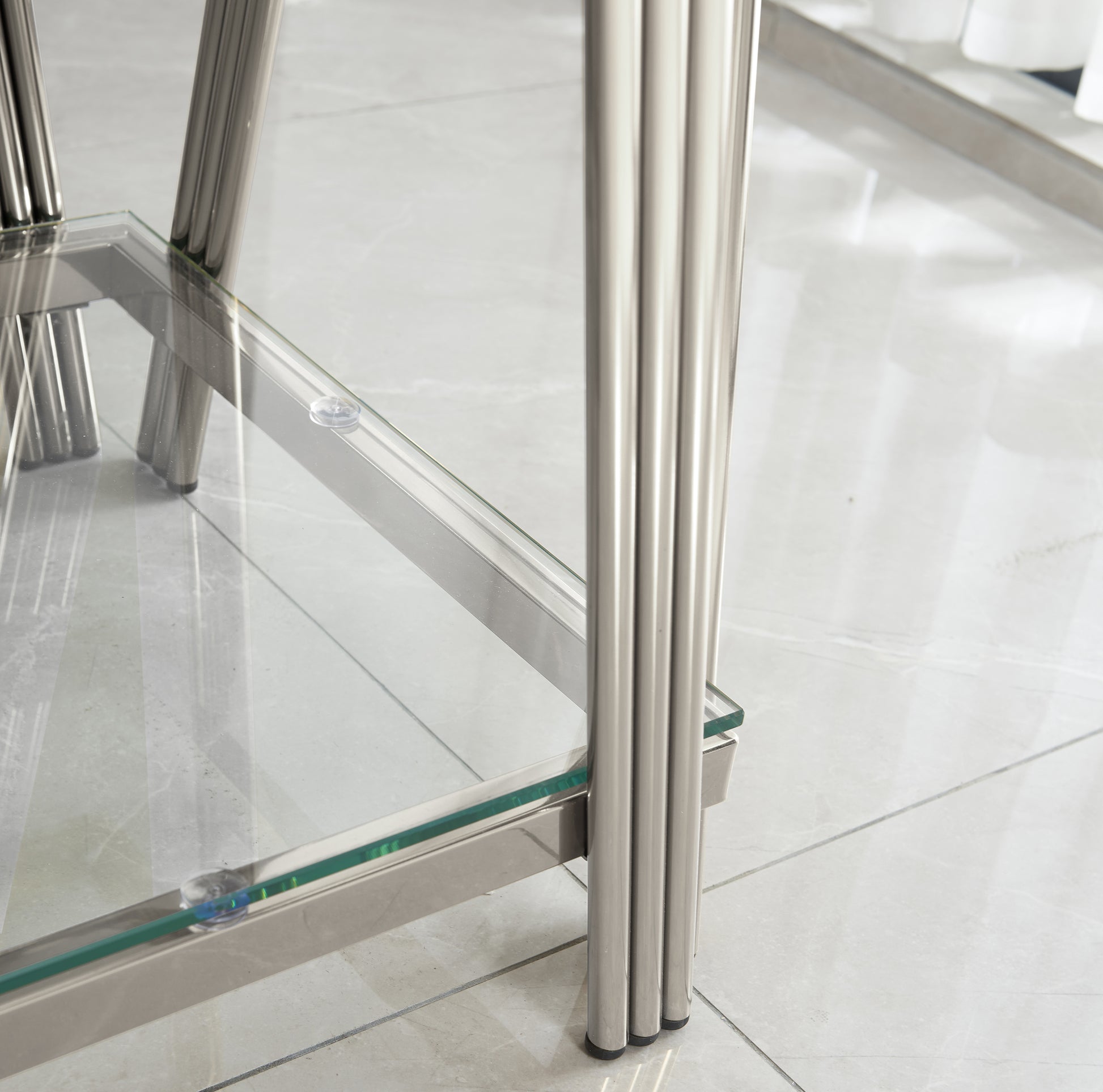 Closeup of silver chrome fluted legs supporting a clear glass table