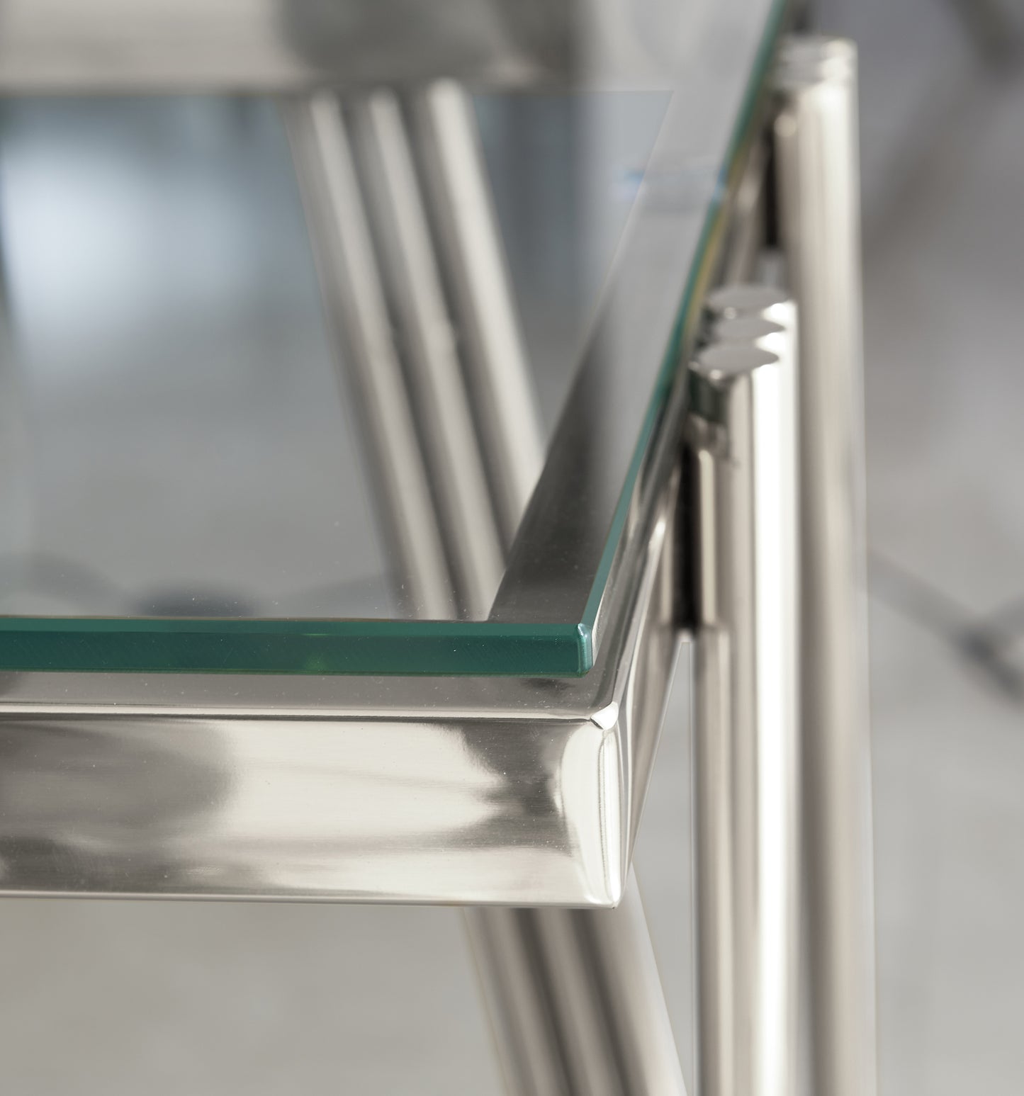 Closeup of polished chrome legs and tempered glass tabletop