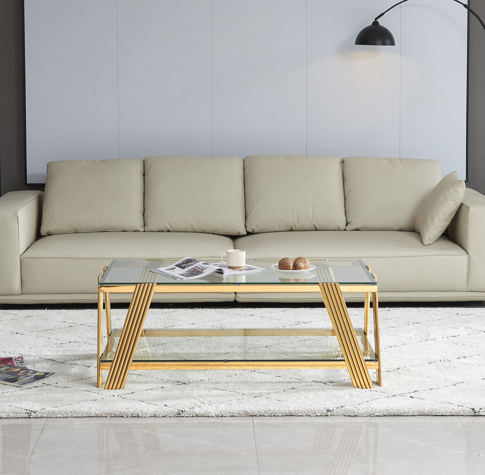 Modern gold coffee table with glass top and shelf
