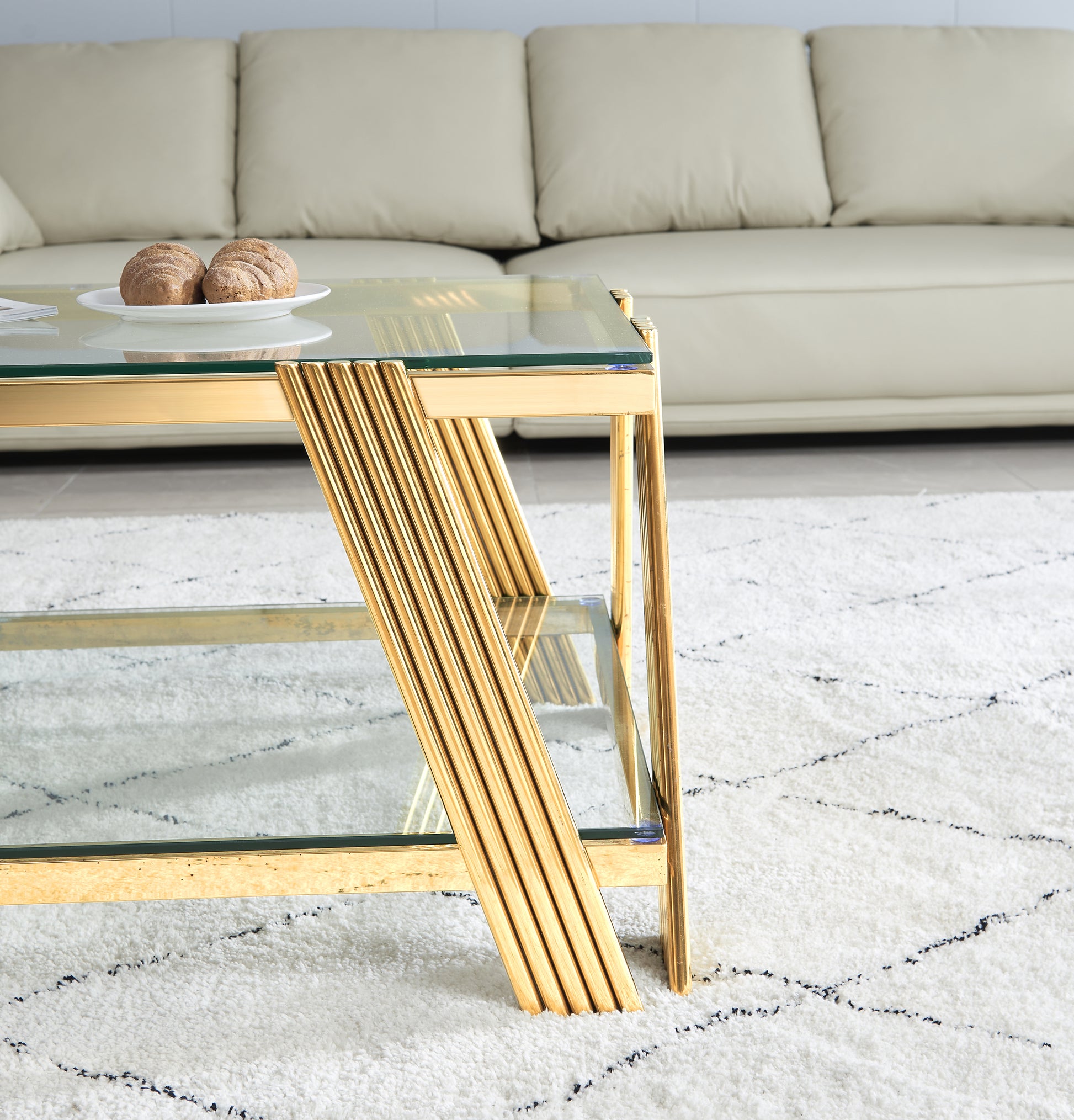 Modern gold coffee table with glass top and ribbed legs