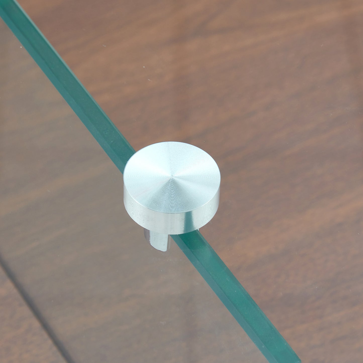 Brushed stainless steel furniture foot on clear glass shelf