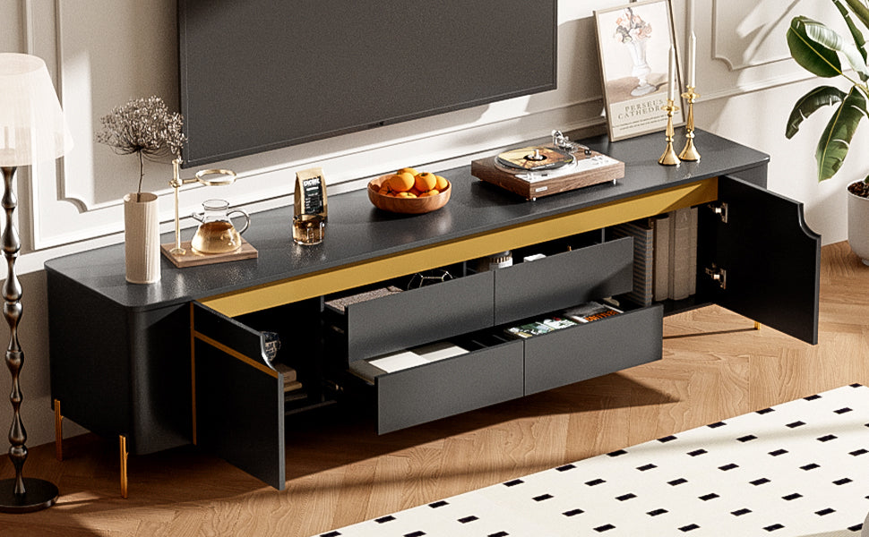 Modern black media console with gold accents and open drawers
