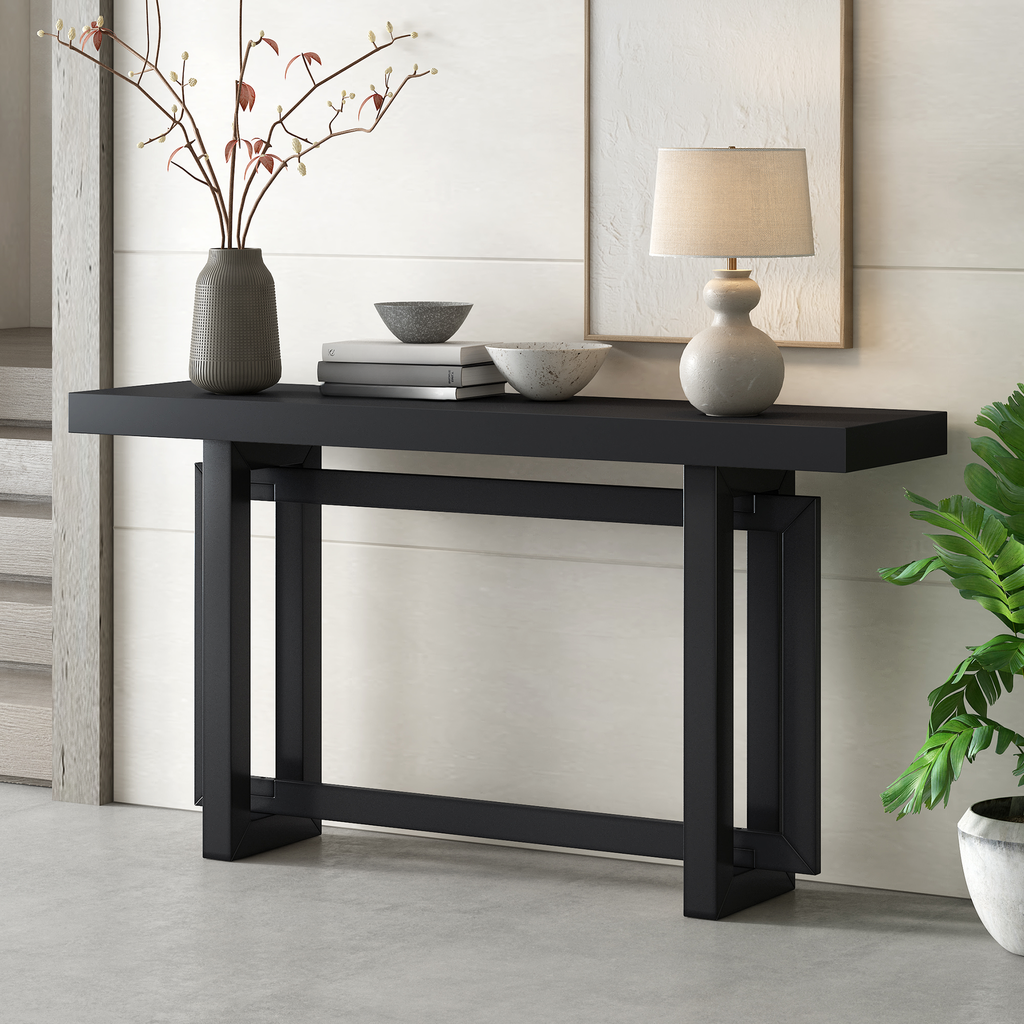 Modern black metal console table with geometric legs and decorative vase