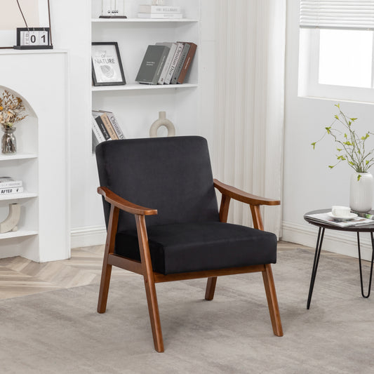 Black velvet accent chair with warm wood frame and tapered legs