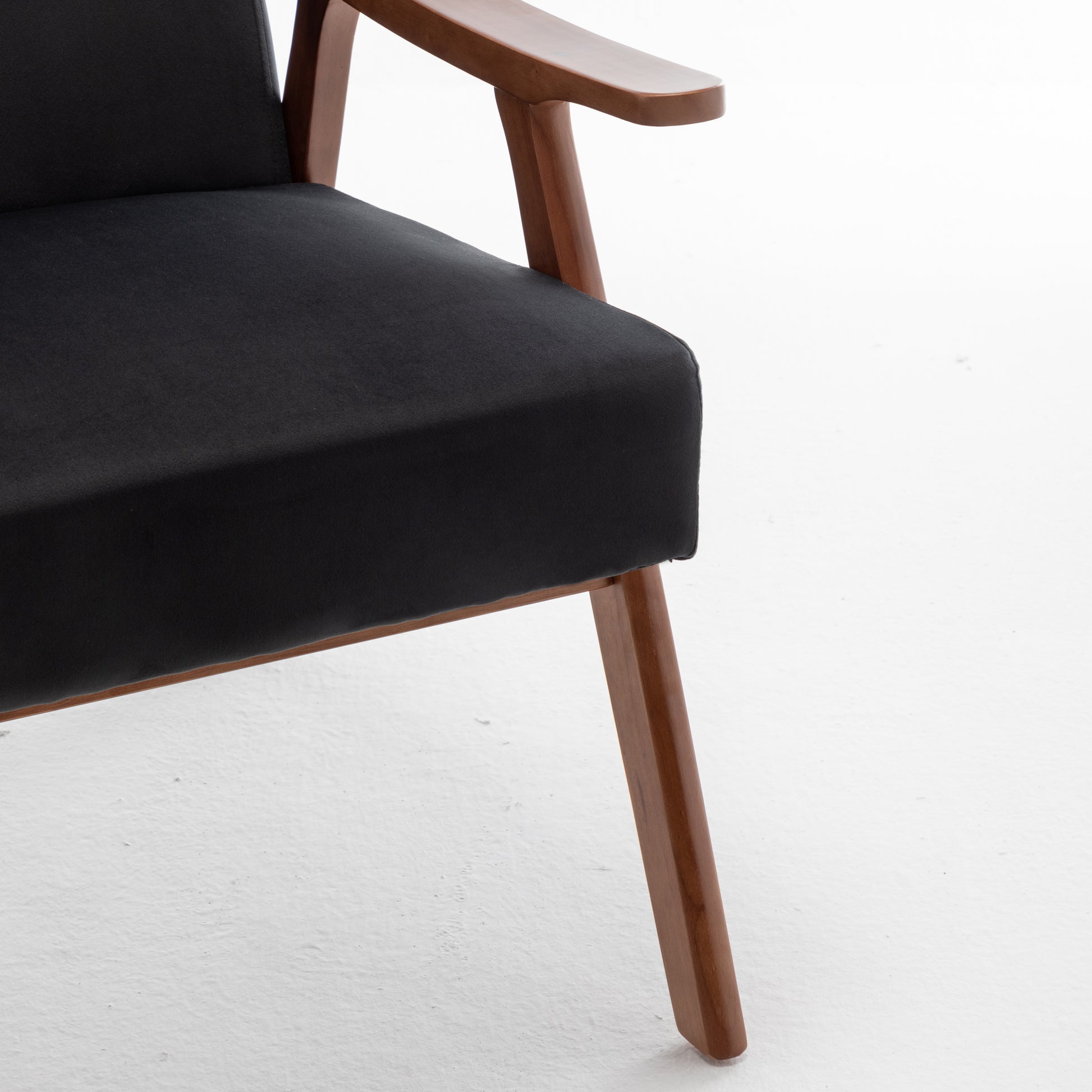 Black fabric armchair with warm wood frame