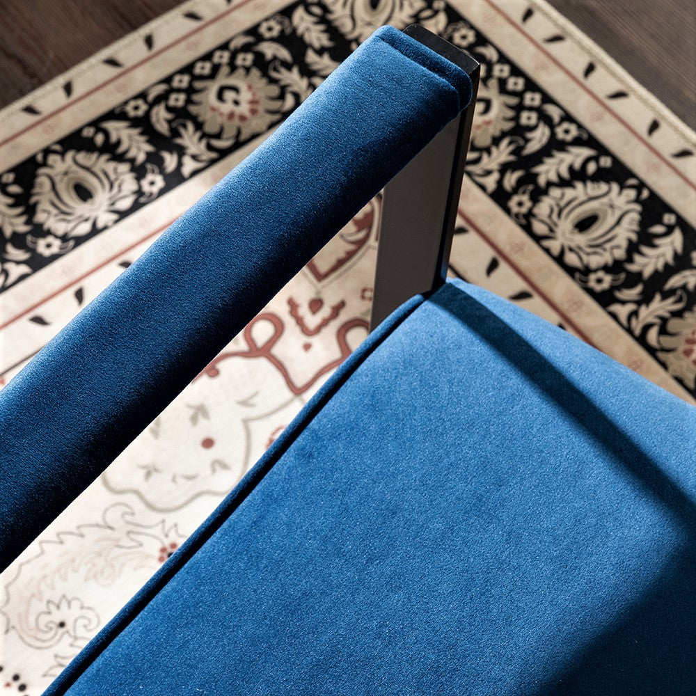Deep blue velvet armchair armrest and seat detail