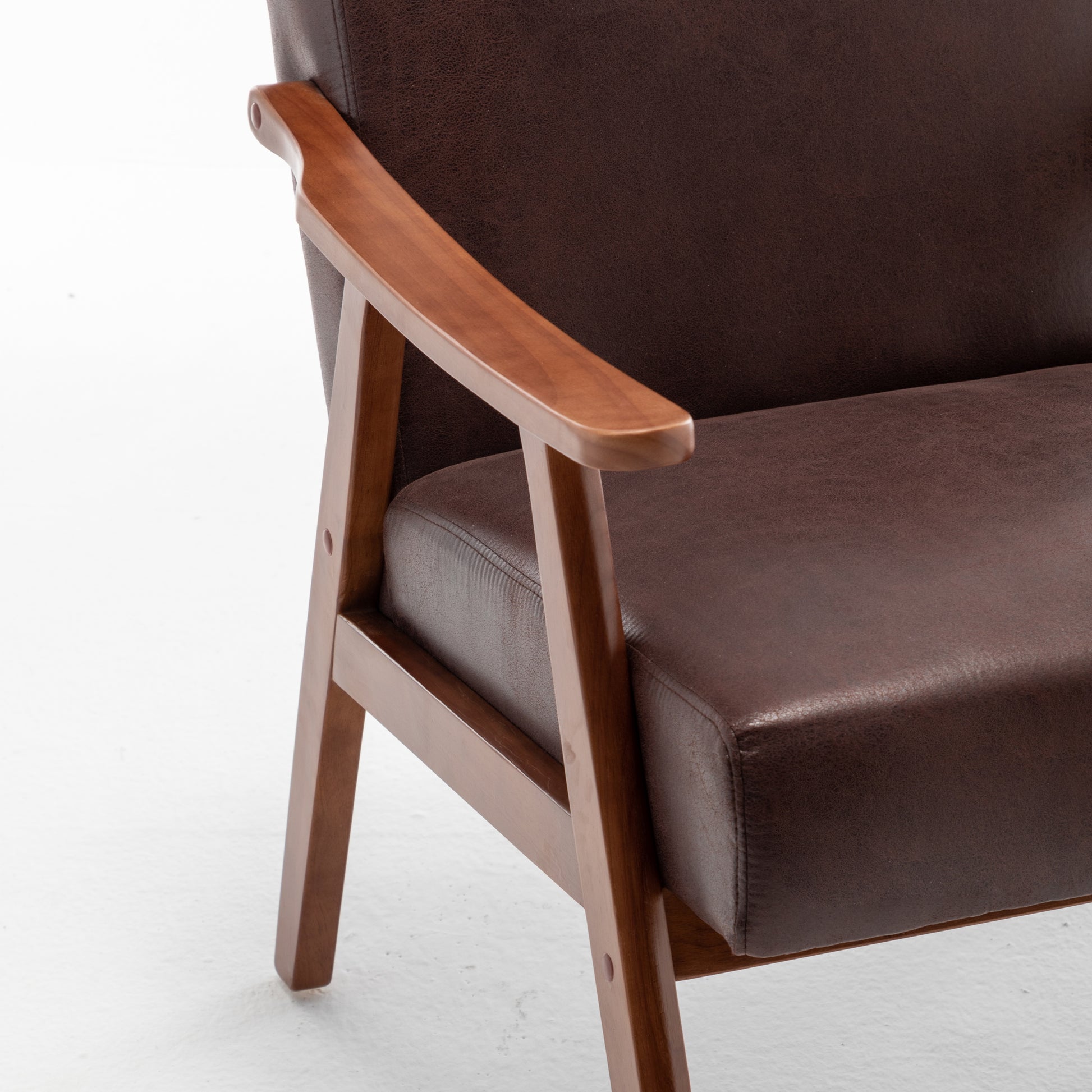 Closeup of a brown faux leather armchair with wooden armrests