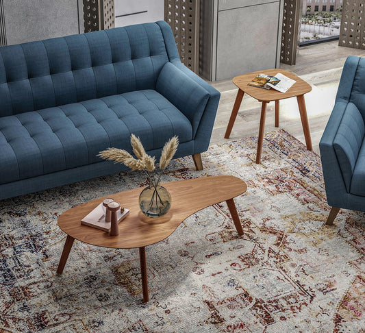 Blue tufted fabric sofa with wooden legs in a modern living room