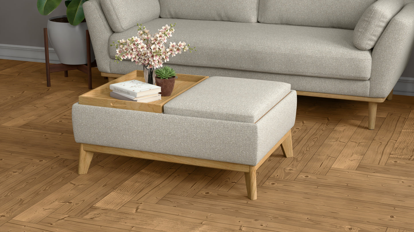Light gray fabric ottoman with wooden legs and a wooden tray holding books