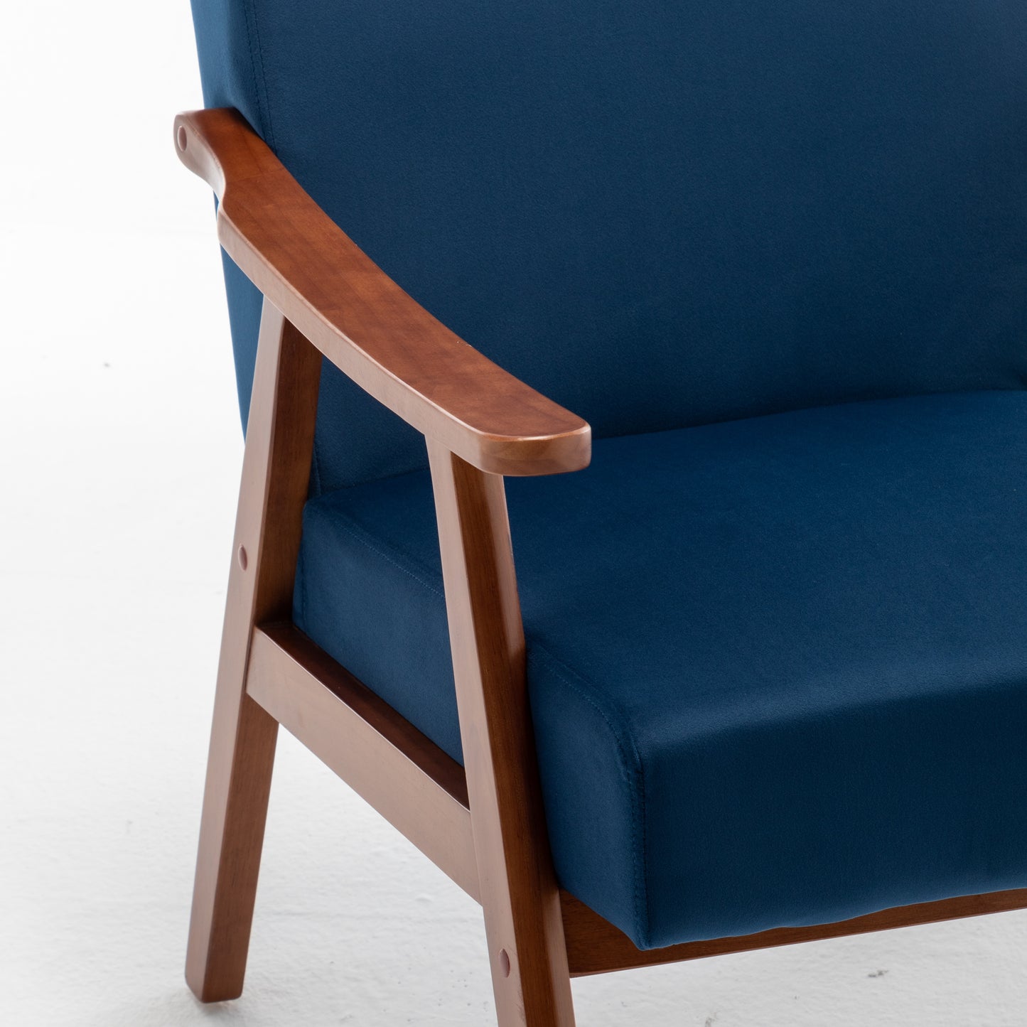 Blue velvet accent chair with warm wood armrests and frame