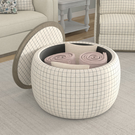 Round storage ottoman with cream and grey plaid fabric holding rolled blankets