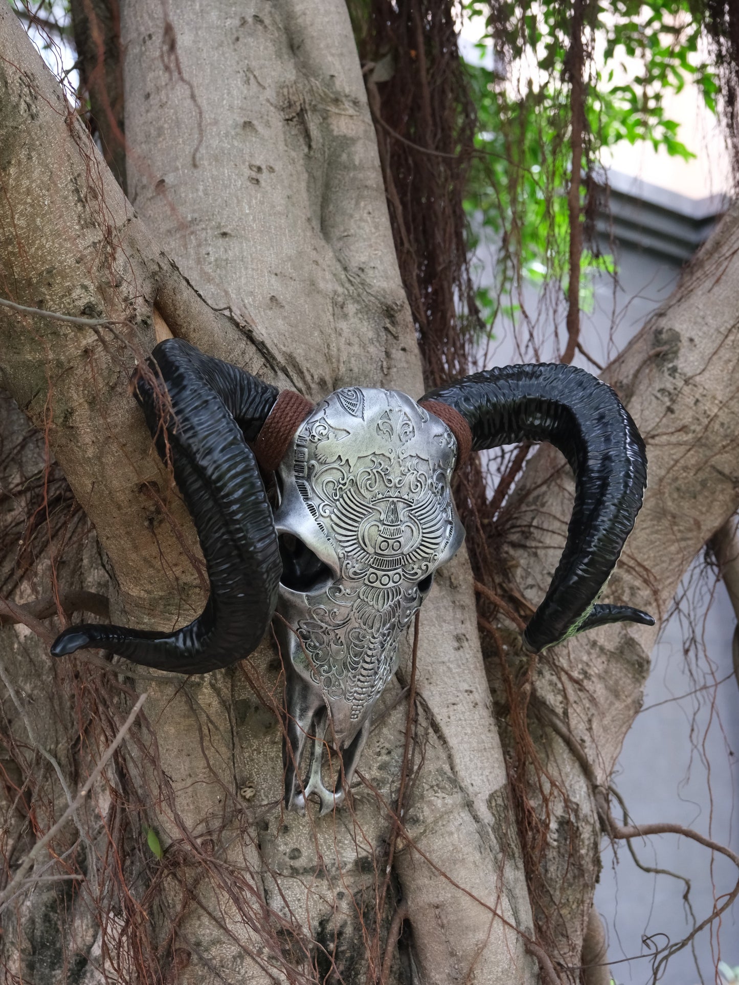 Ornate silver ram skull with black horns