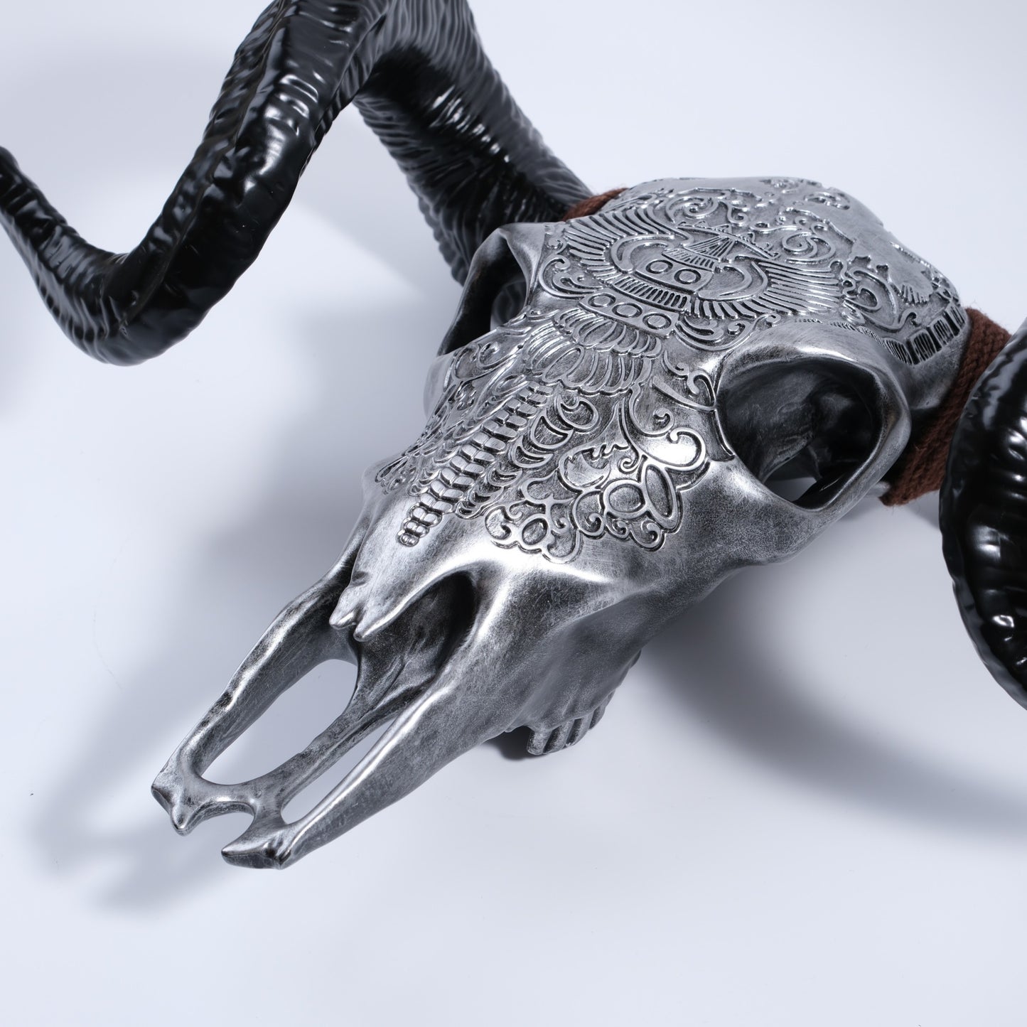 Silver ram skull wall decor with ornate tribal engravings and black curved horns