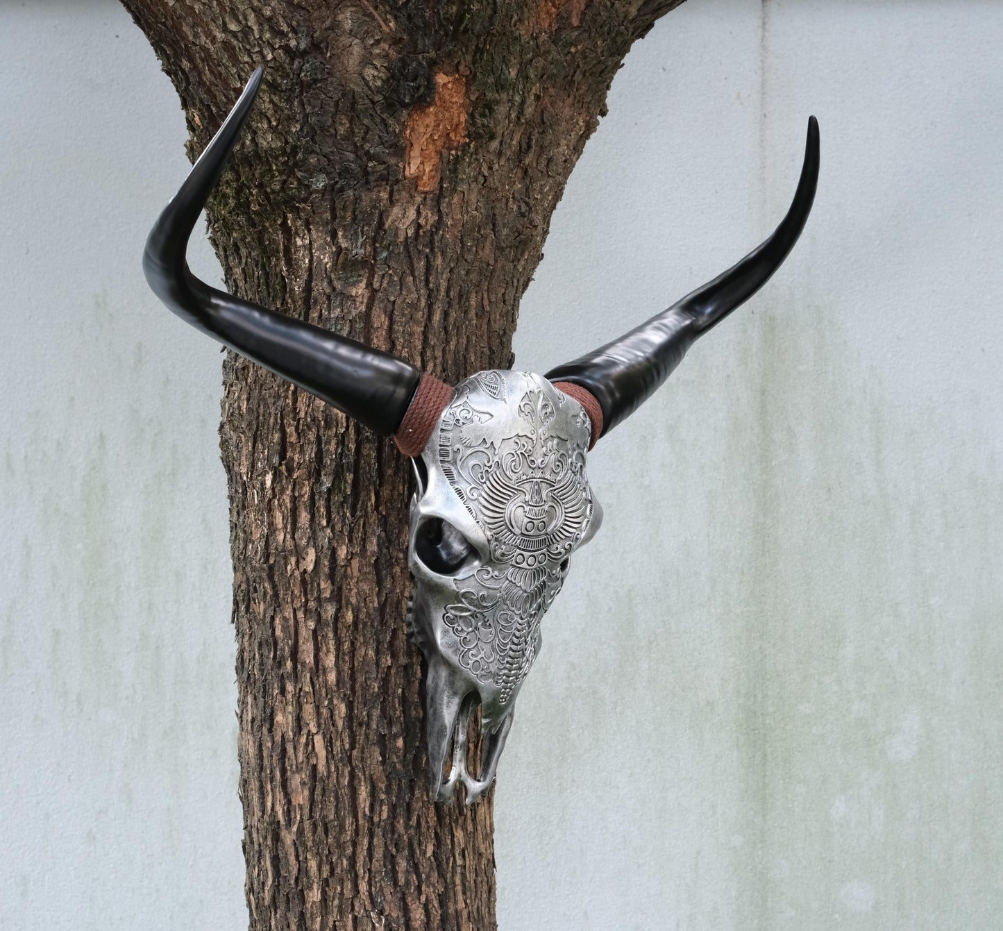 Decorative bull skull with intricate silver carvings and black horns
