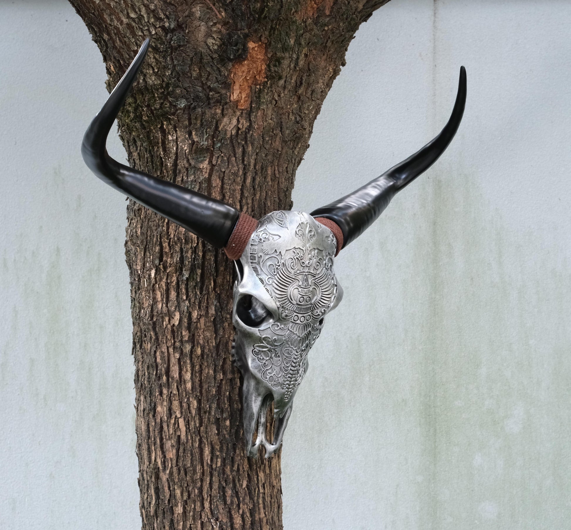 Decorative bull skull with intricate silver carvings and black horns