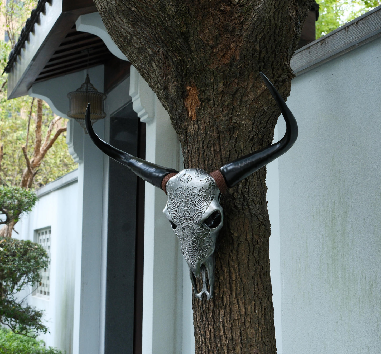 Silver skull wall art with dark horns and intricate tribal engravings