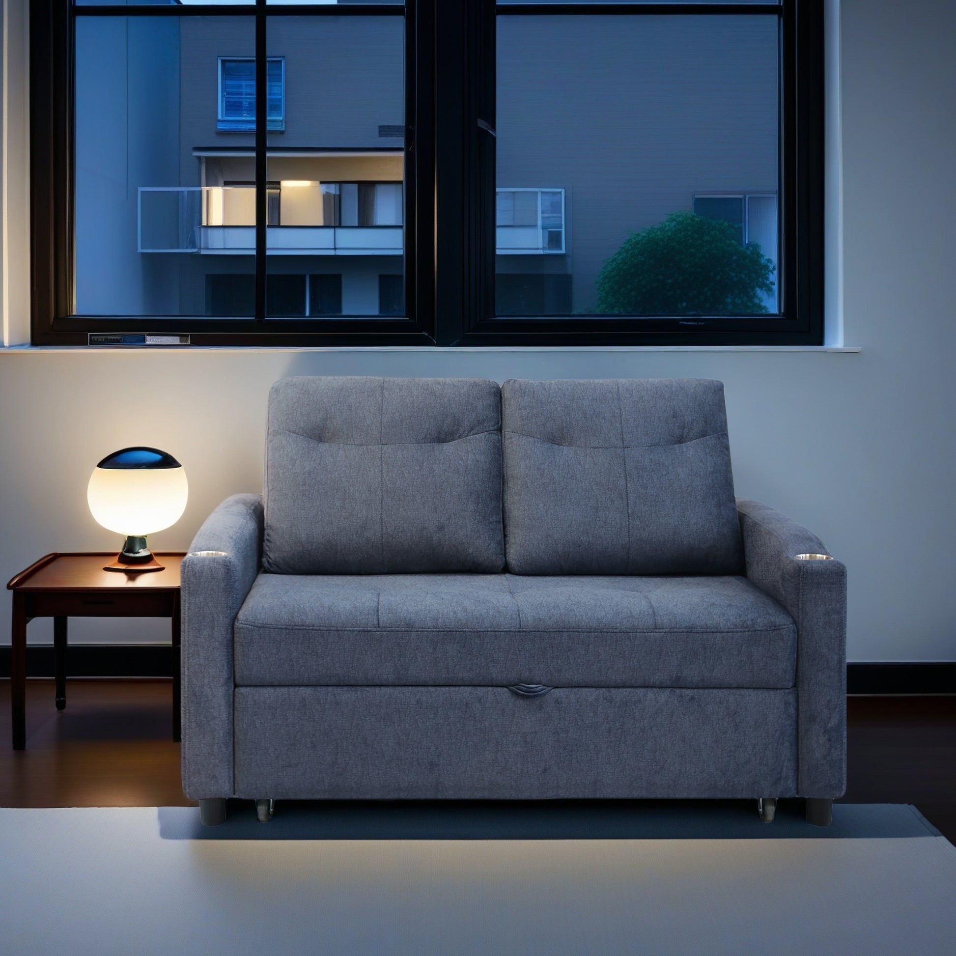 Gray fabric sofa bed with tufted cushions and builtin cup holders
