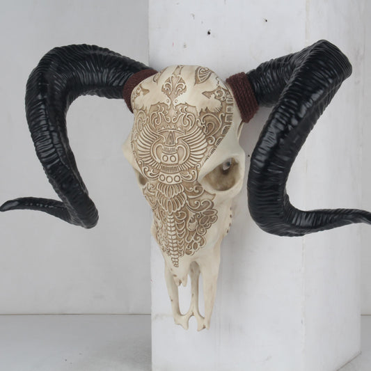 Ornate carved skull with large black ram horns