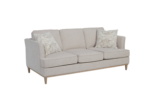 Light beige linen threeseater sofa with two decorative throw pillows