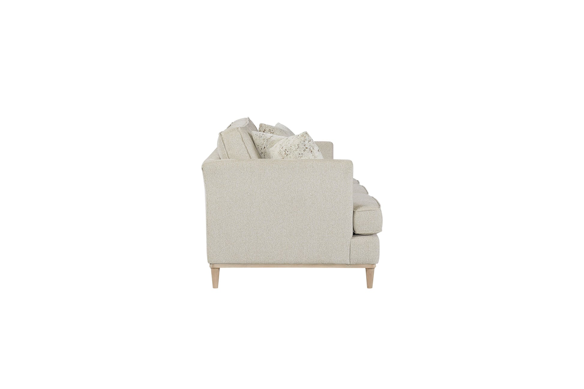 Side view of a light beige fabric sofa with plush cushions and wooden legs