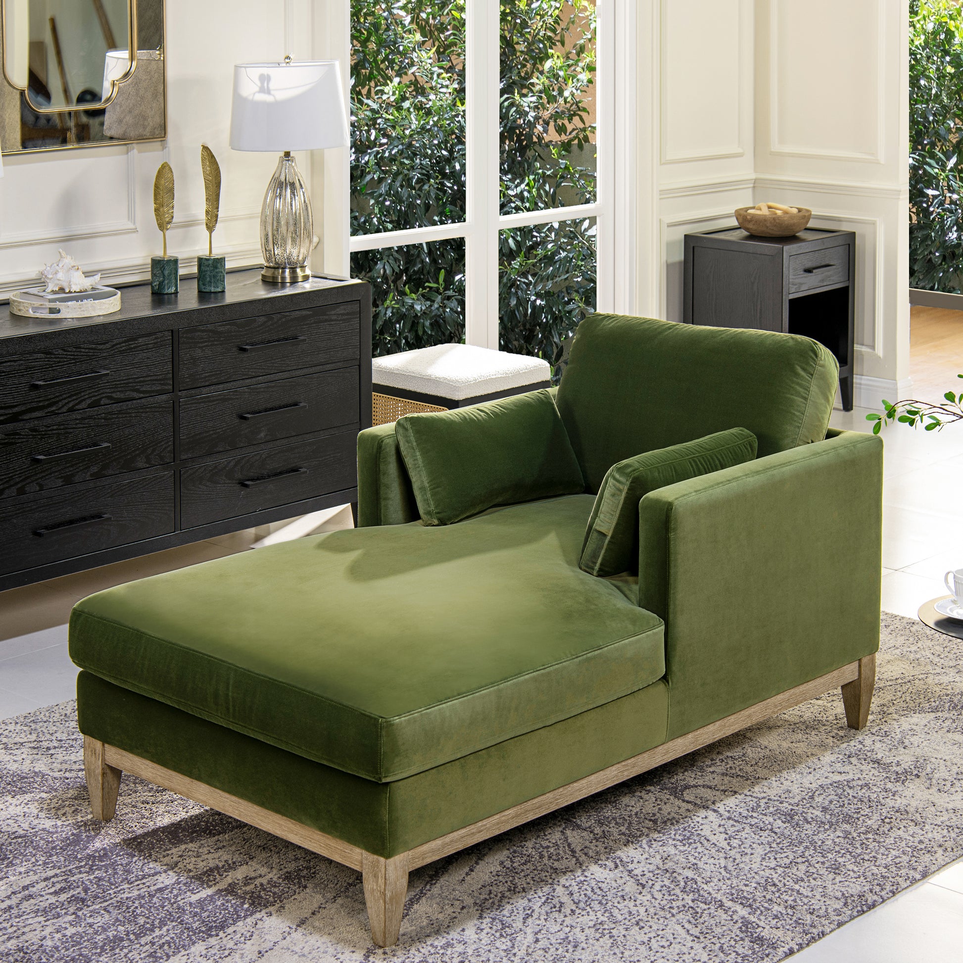 Green velvet chaise lounge with wooden legs and modern design