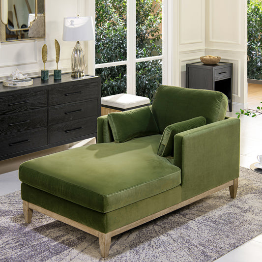 Green velvet chaise lounge with wooden legs and modern design