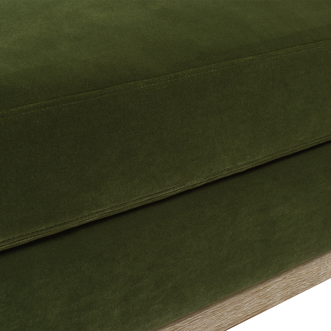 Closeup of textured moss green velvet fabric detail on a sofa cushion