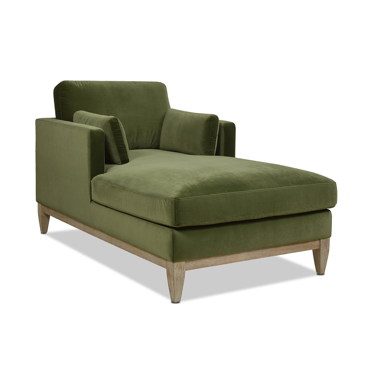Green velvet chaise lounge with wooden legs and plush accent pillows