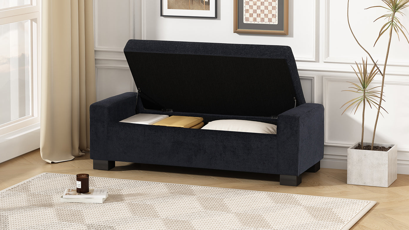 Dark navy upholstered storage bench with open lid revealing linens