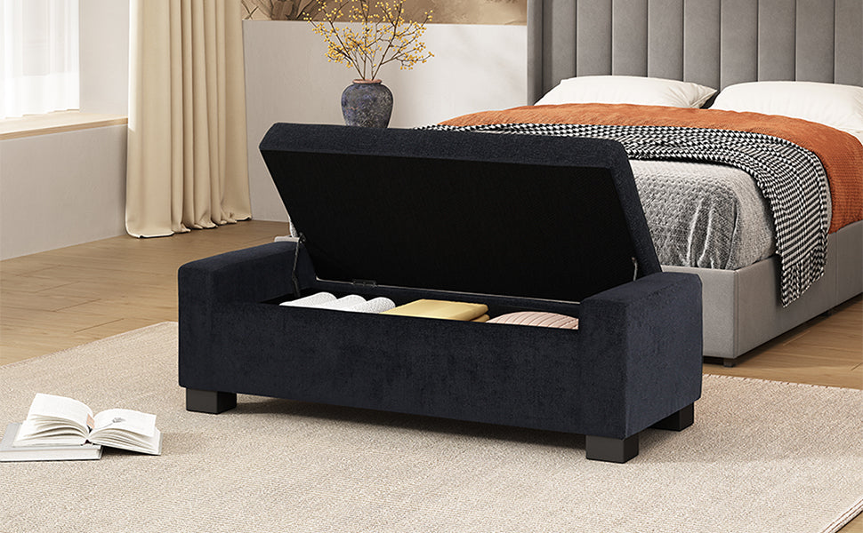 Dark navy fabric storage bench with lid open showing stored blankets