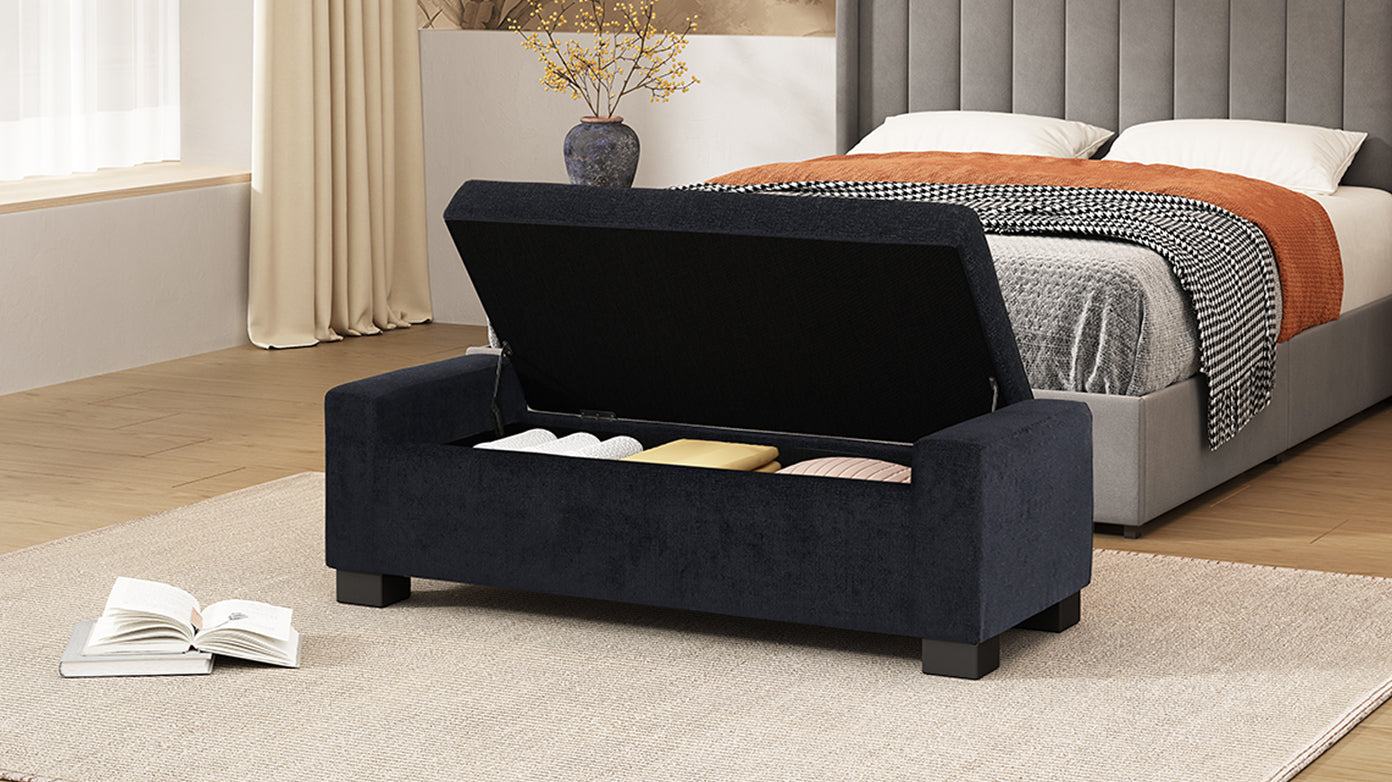 Dark blue velvet storage bench with lid open showing blankets