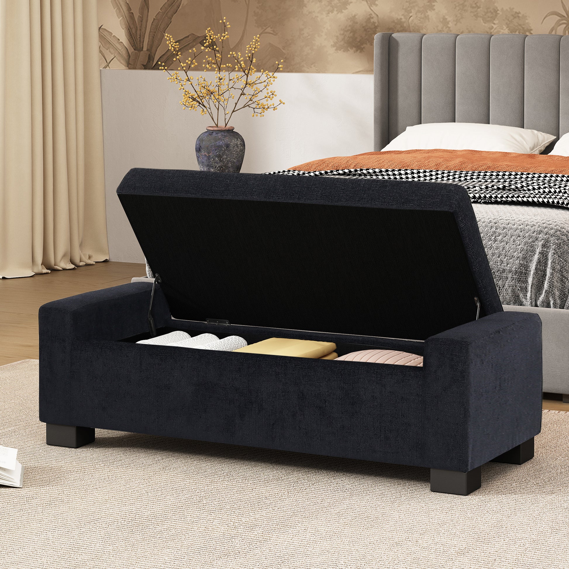 Dark blue upholstered storage bench with open lid revealing storage items inside