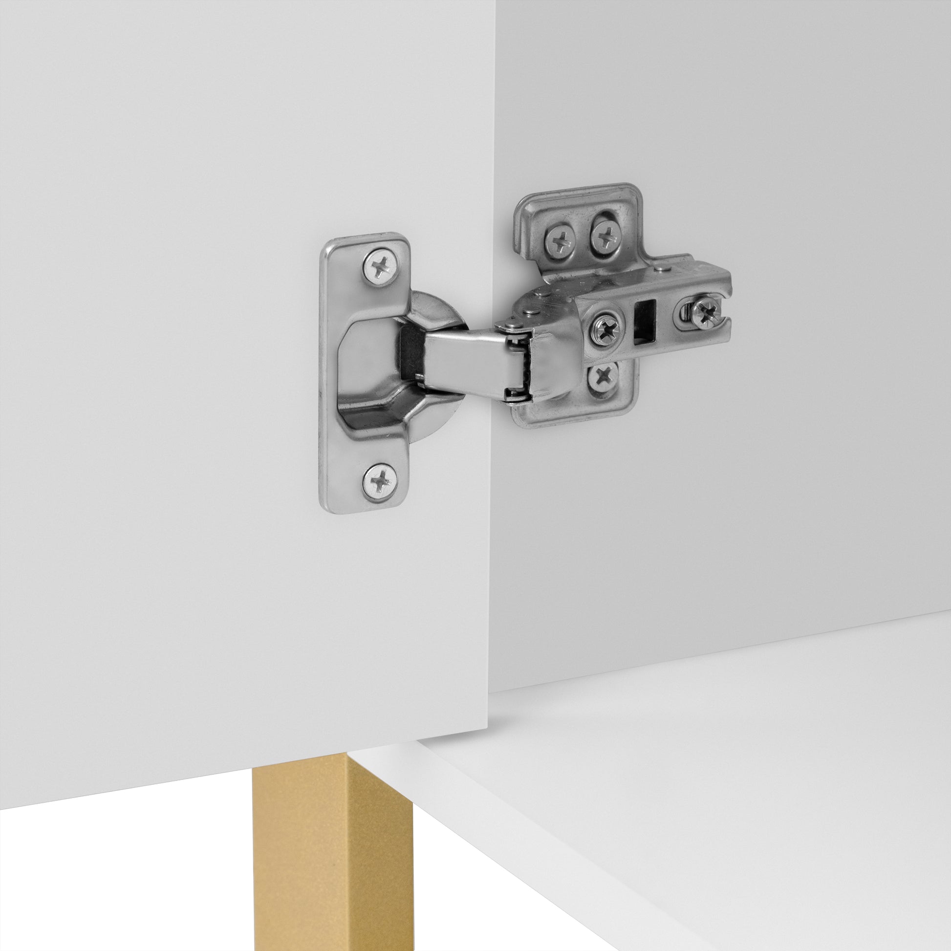 Closeup of chrome cabinet hinges with screws on white furniture door