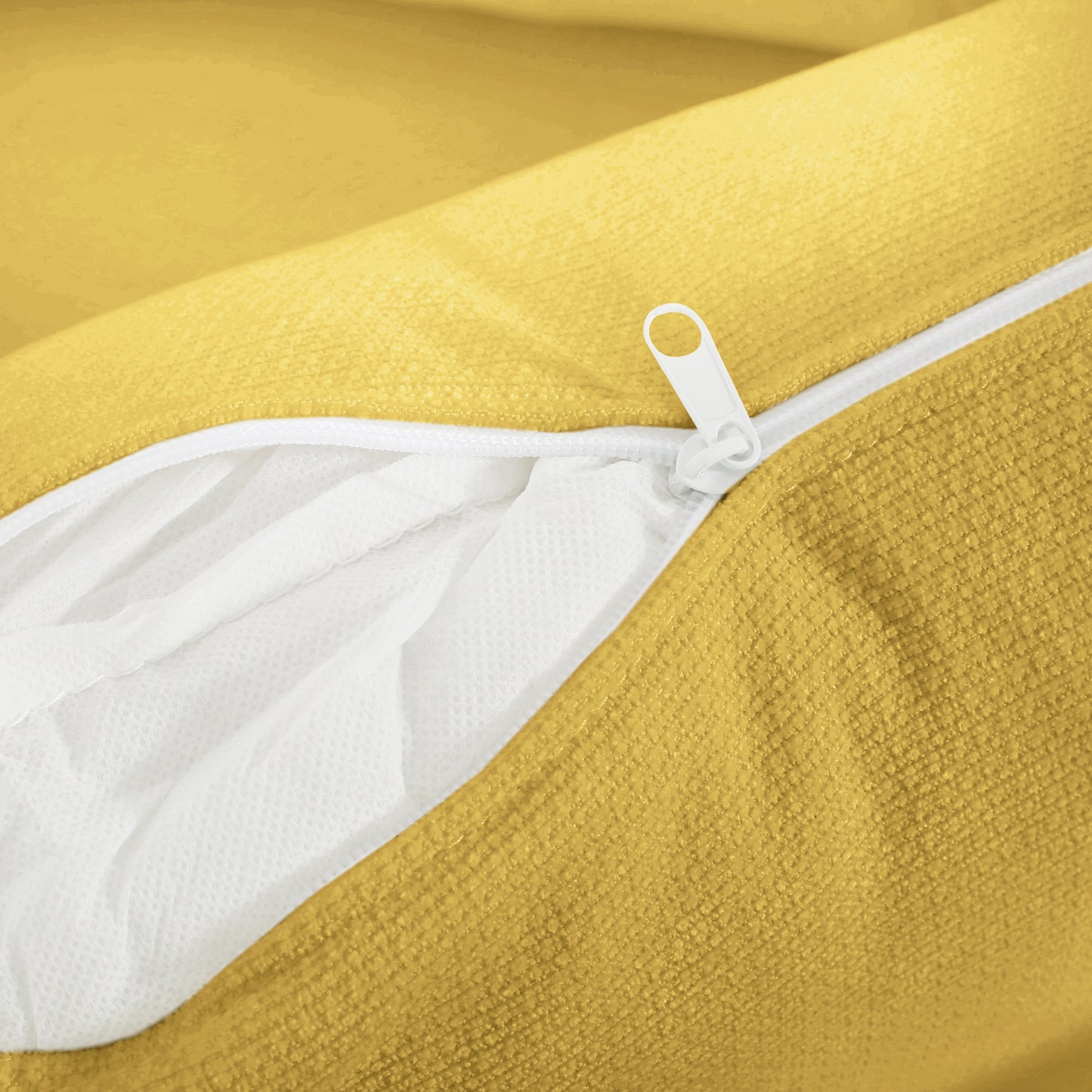 Closeup of a textured yellow fabric with a white zipper partially open revealing white inner lining