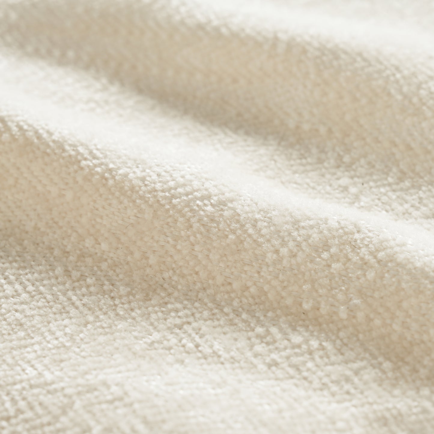 Closeup of creamy white chenille fabric texture with soft ripples for upholstery