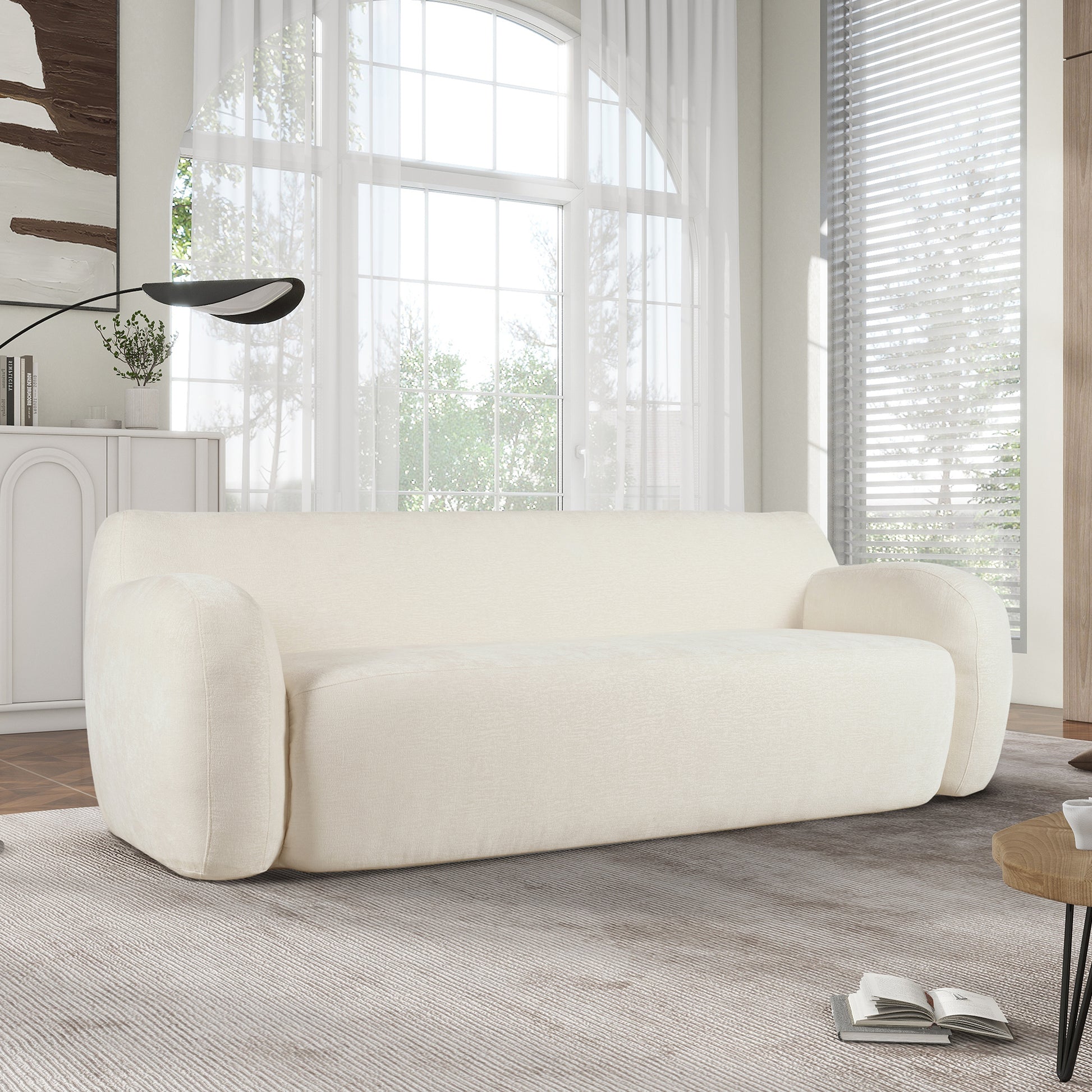 Cream fabric sofa with rounded arms and plush cushioning perfect for a modern living room