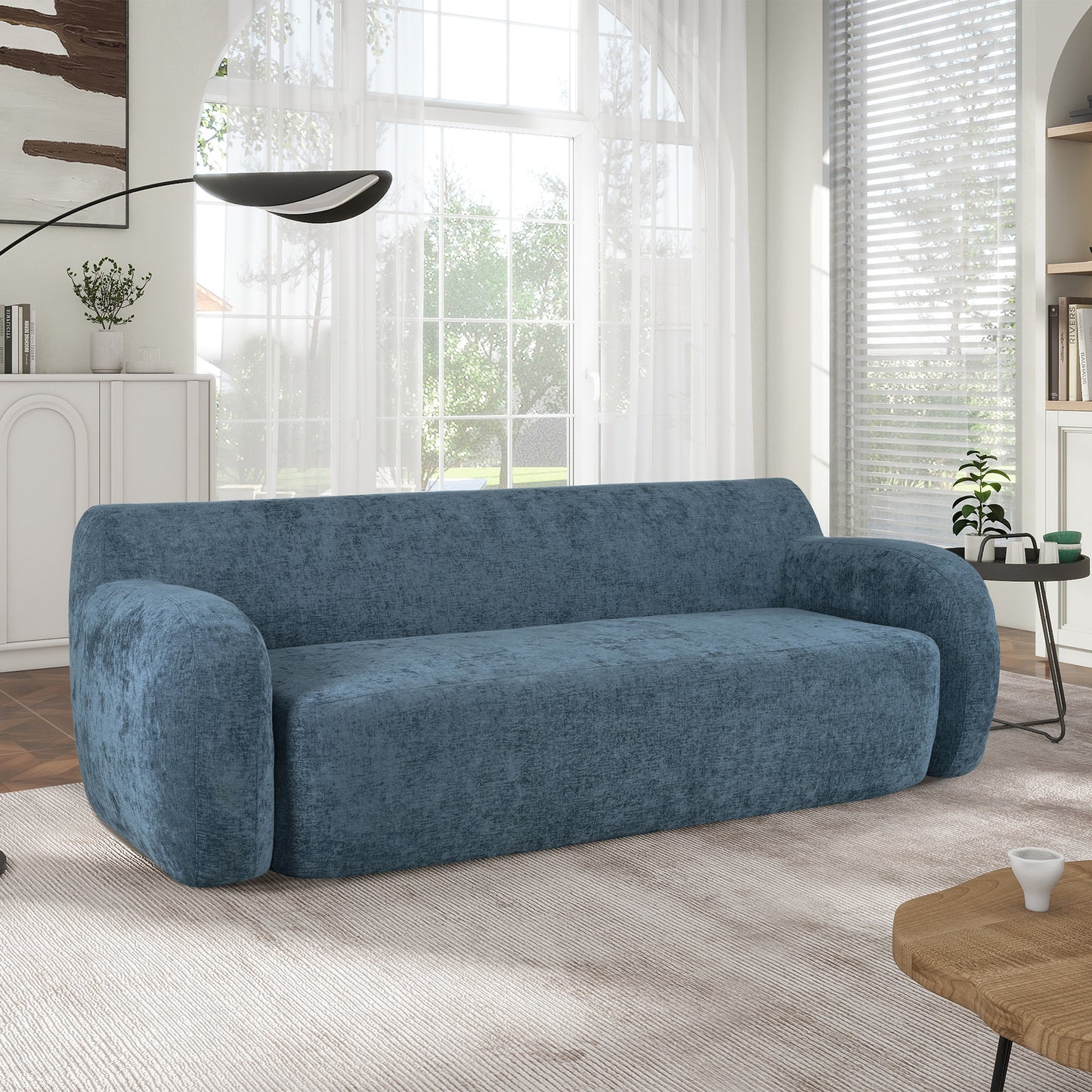 Plush blue velvet sofa with rounded arms