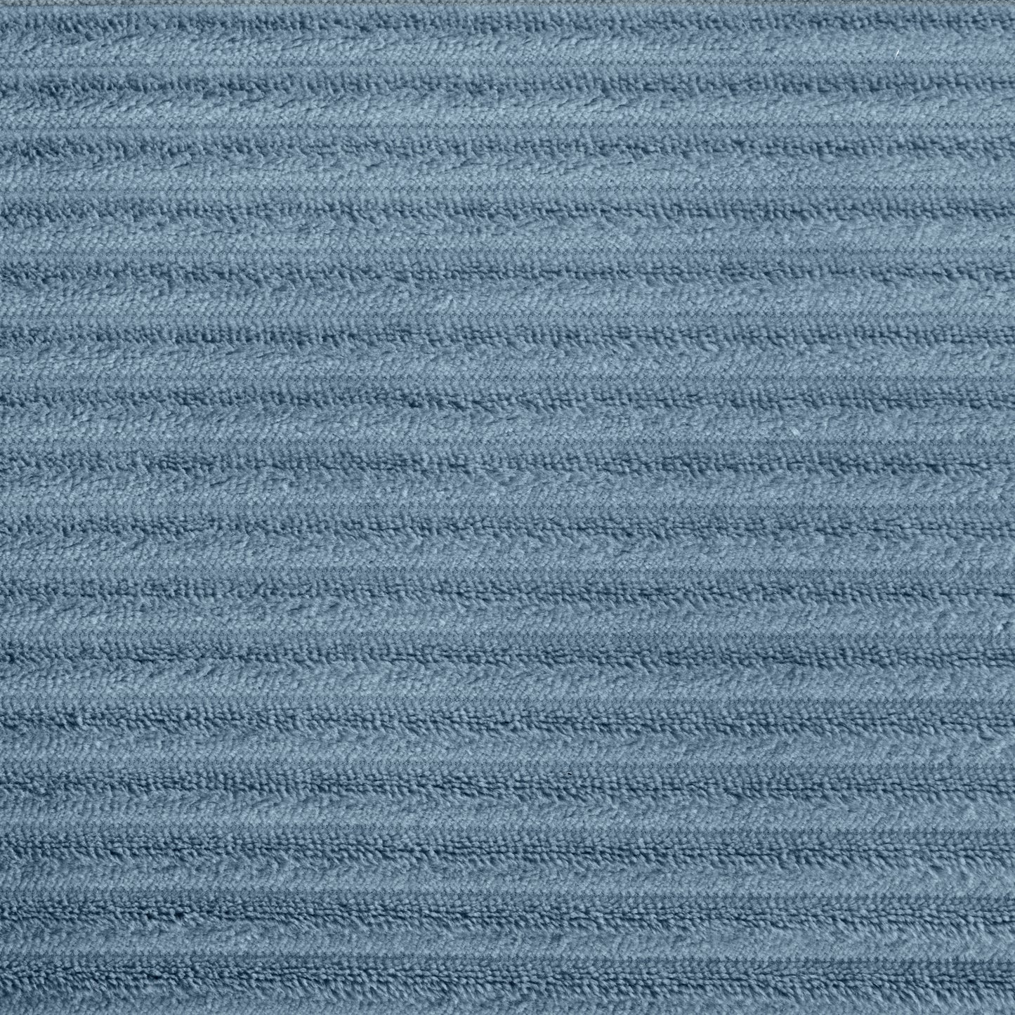 Closeup of dusty blue corduroy fabric with raised parallel ridges for texture