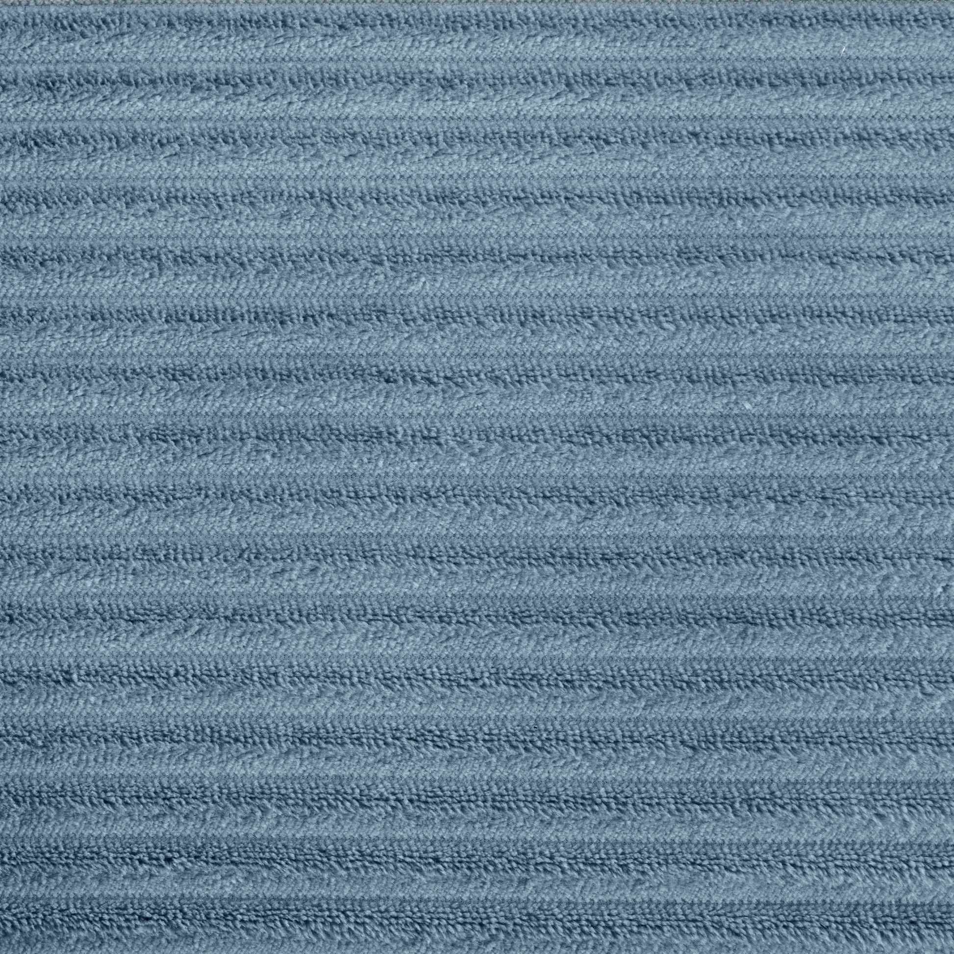 Closeup of dusty blue corduroy fabric with raised parallel ridges for texture