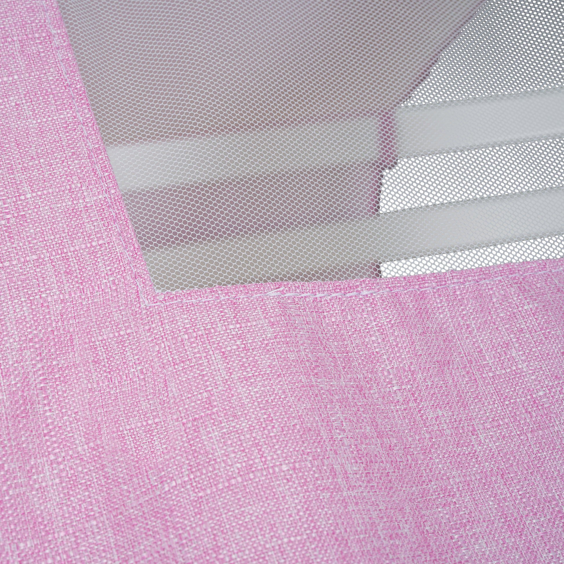 Closeup of pink textured fabric with white mesh overlay