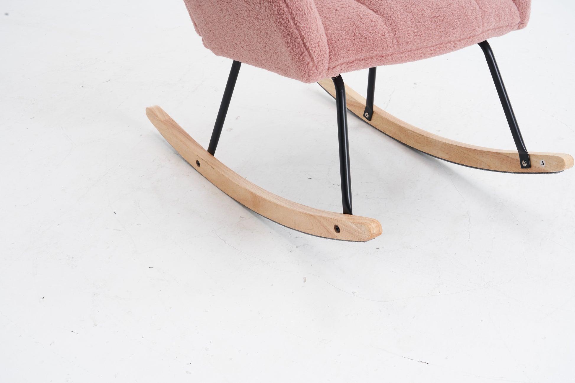 Pink boucle fabric armchair with natural wood rocking base and black metal legs