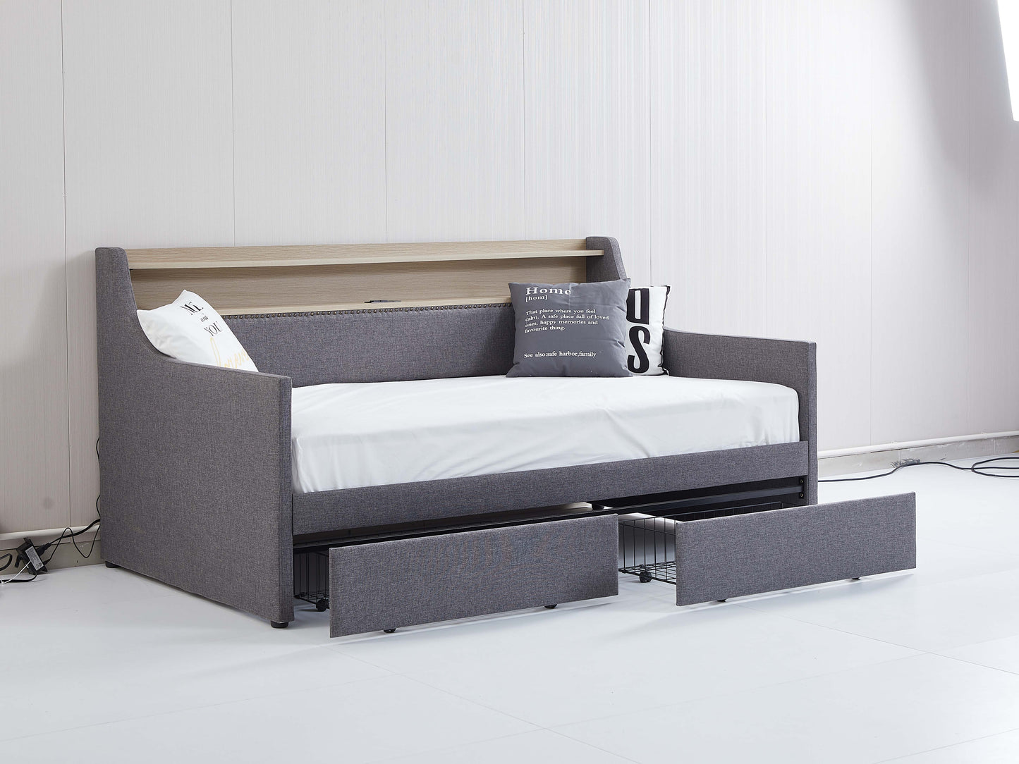 Grey upholstered daybed with wood accents and two pullout drawers