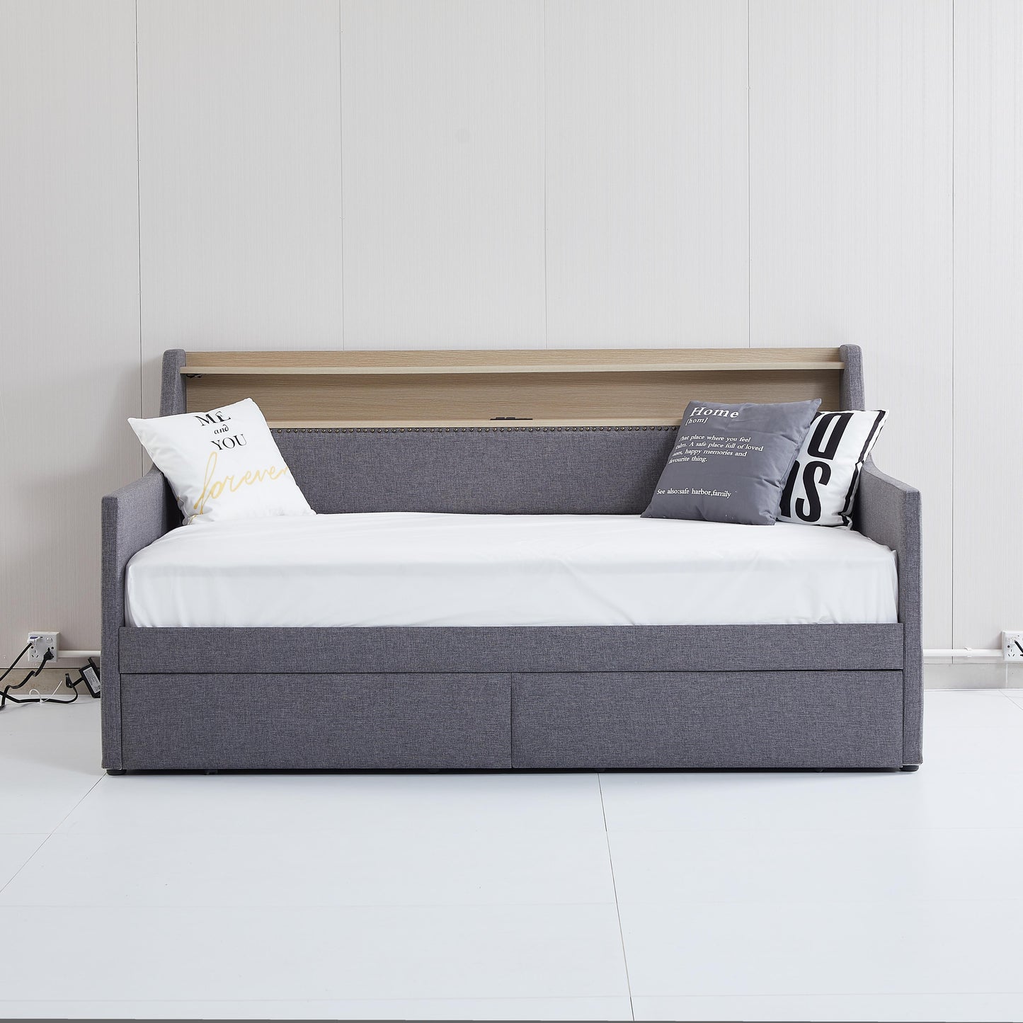 Grey fabric daybed with a pullout trundle and wooden shelf