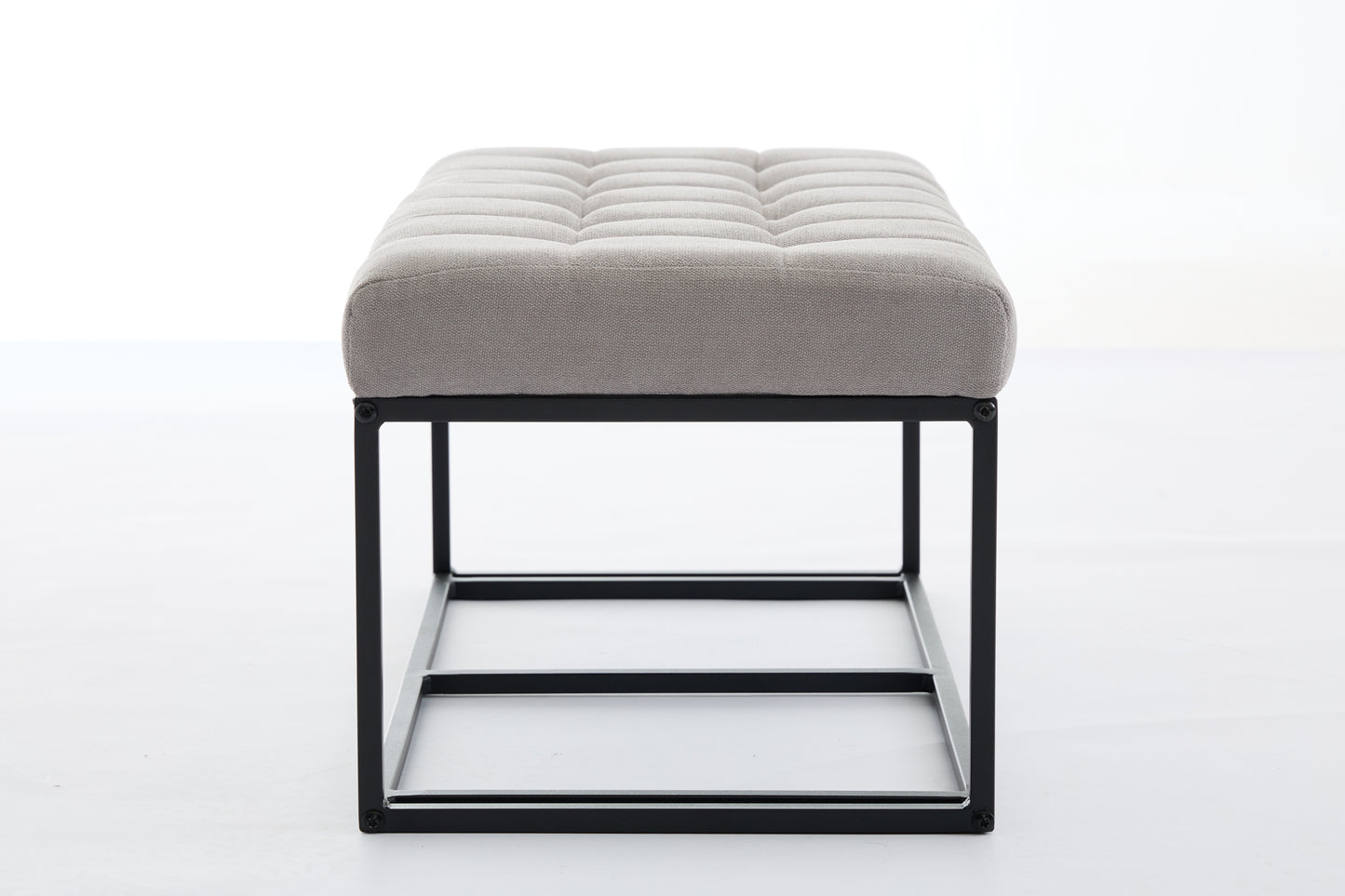 Gray fabric ottoman with tufted top and black metal frame