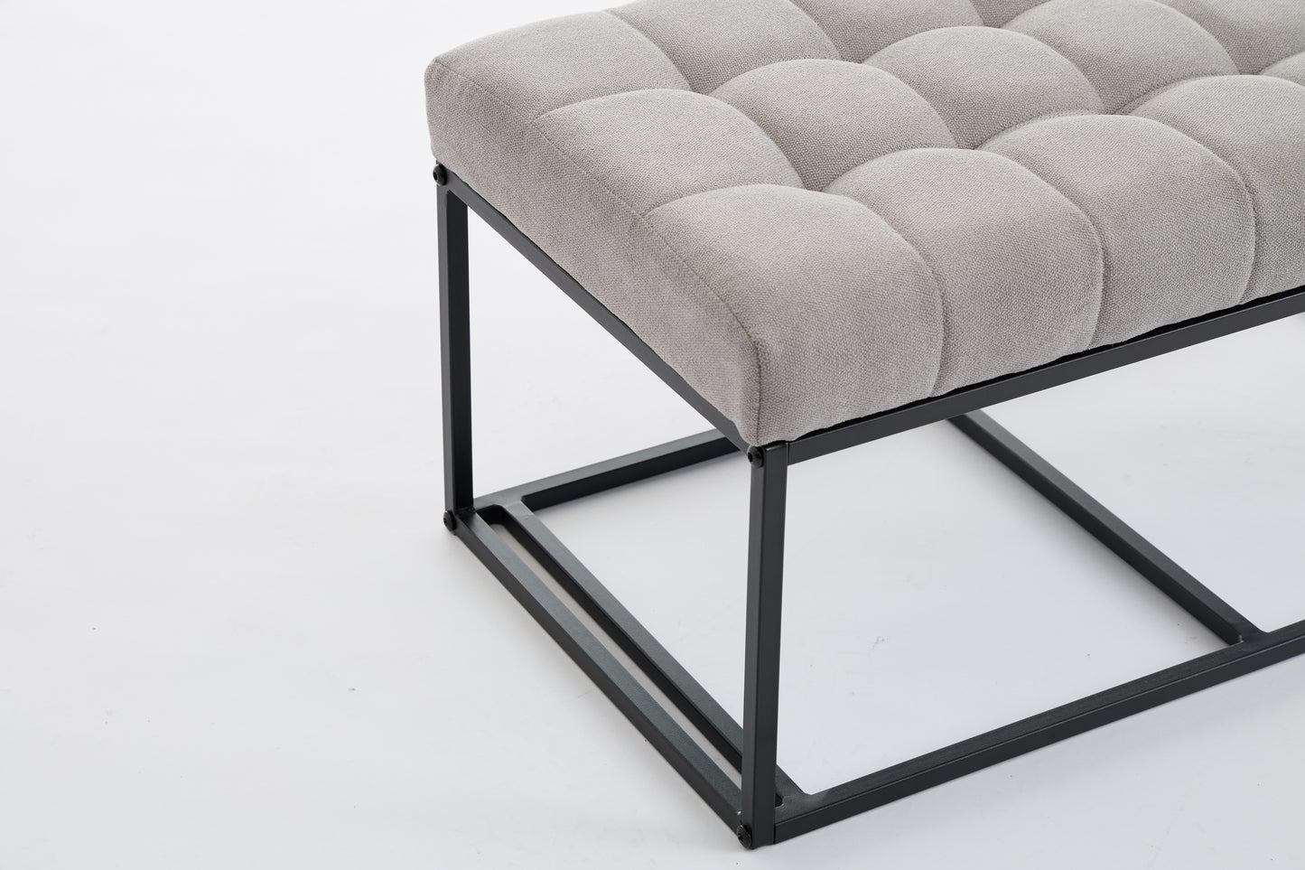 Tufted gray fabric ottoman with a modern black metal frame