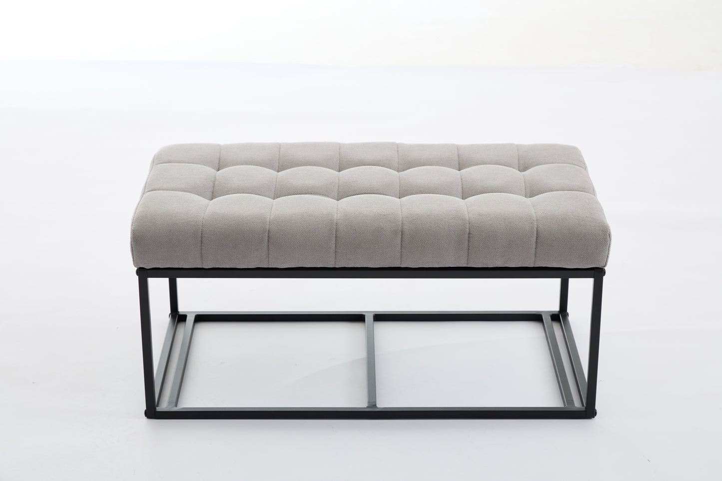 Tufted grey fabric ottoman with black metal frame and legs
