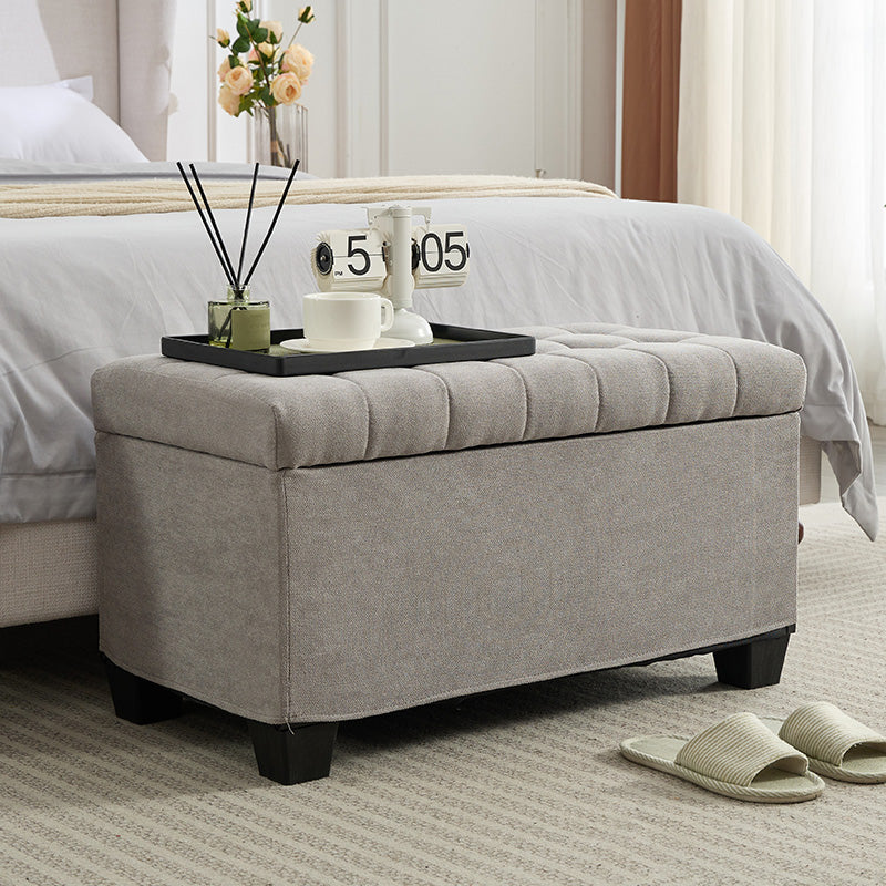 Gray tufted storage ottoman with dark wood legs