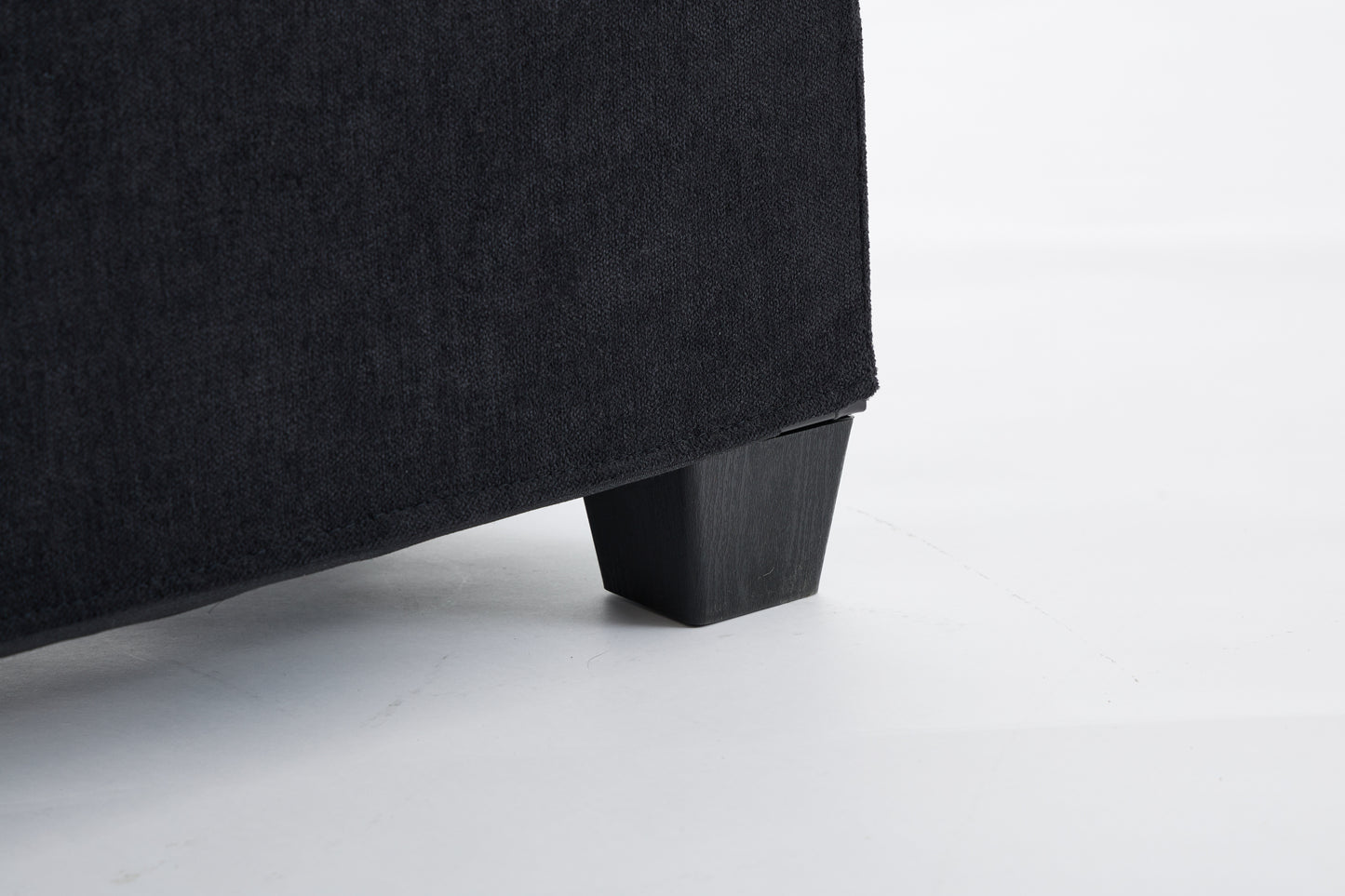 Black fabric sofa with a dark wood leg