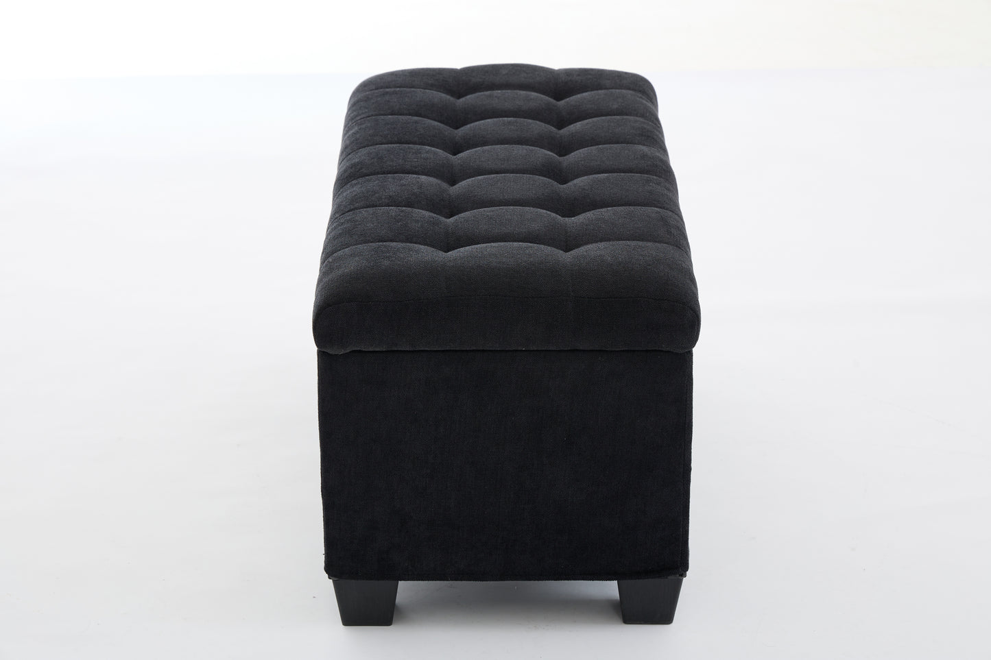 Black tufted storage ottoman with dark fabric upholstery and square wooden legs