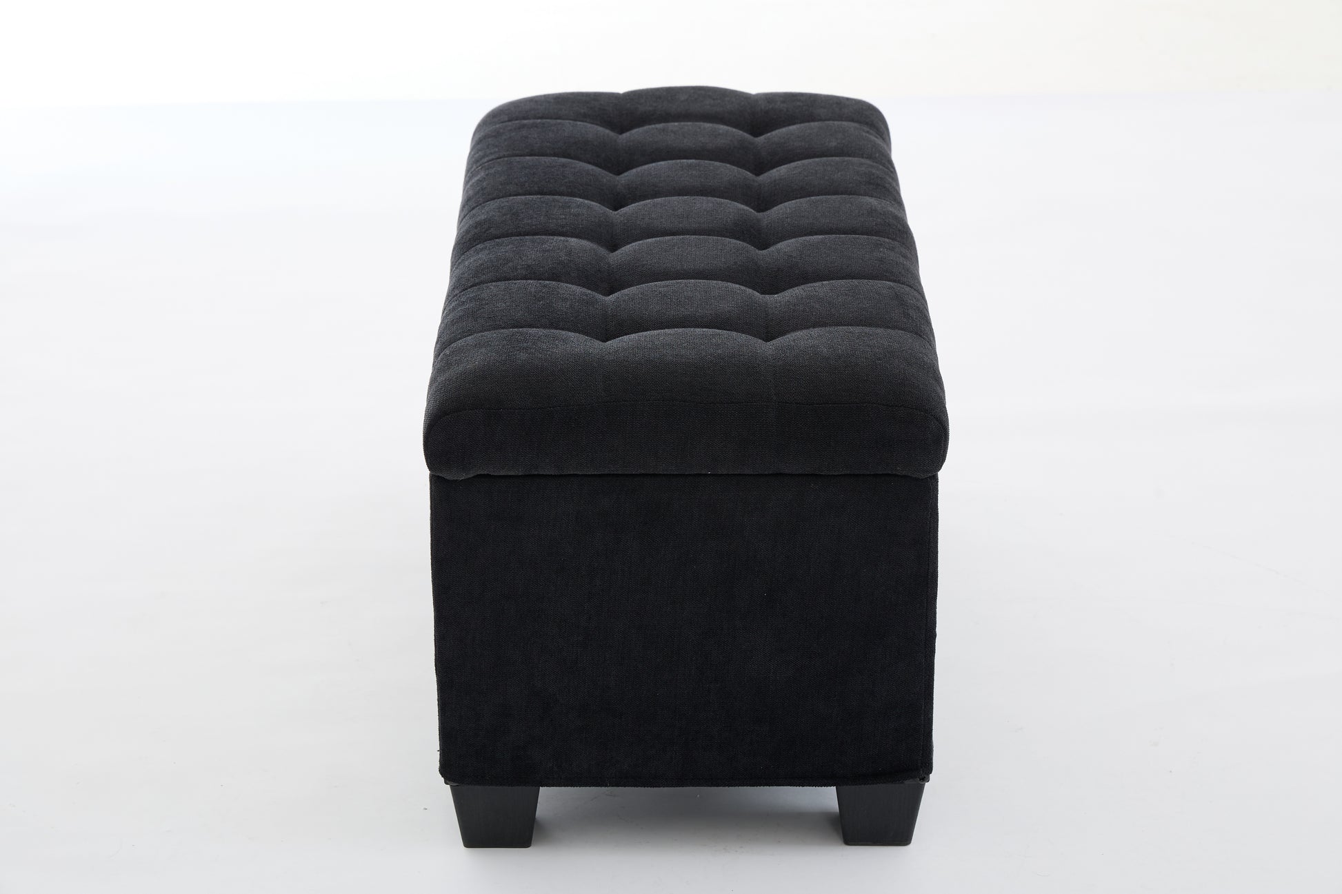 Black tufted storage ottoman with dark fabric upholstery and square wooden legs
